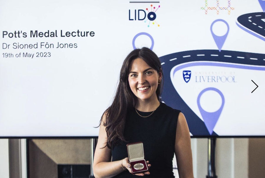 Dr Sioned Fôn Jones holding the Potts Medal at her lecture