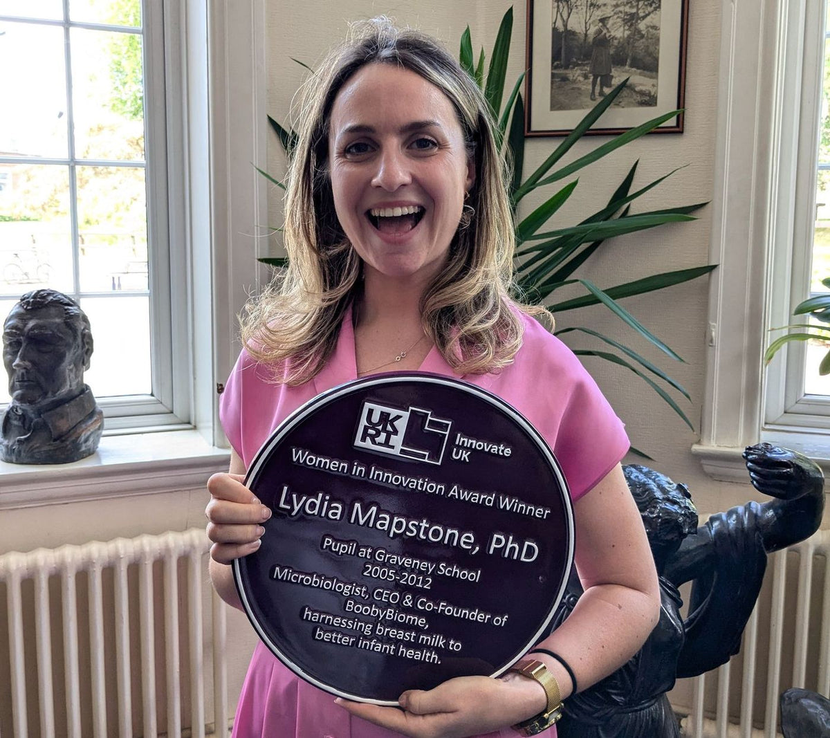 Dr Lydia Mapstone holding her Innovate UK purple plaque